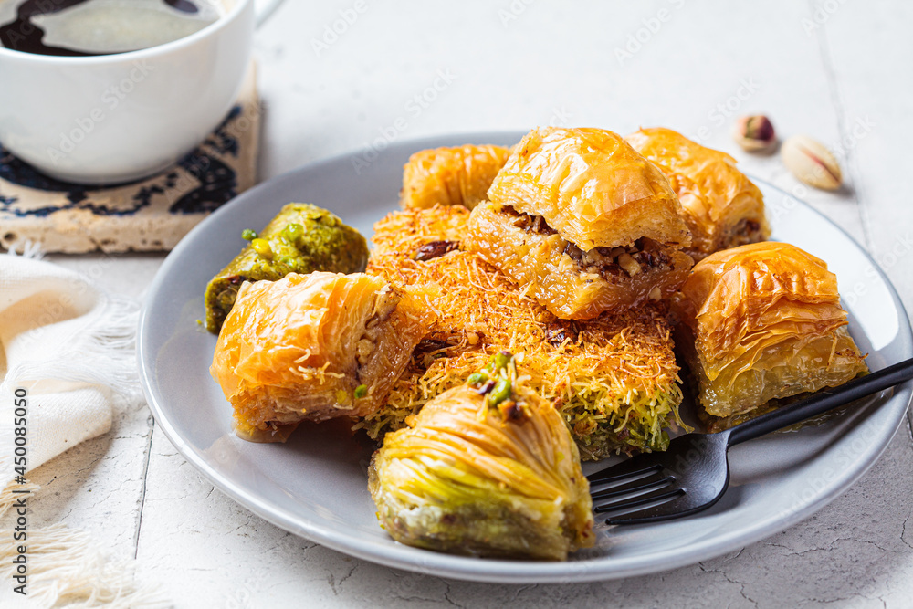 Fresh assorted baklava on gray plate, gray tiles background. Turkish dessert concept. Fresh assorted baklava on gray plate, gray tiles background. Turkish dessert concept.