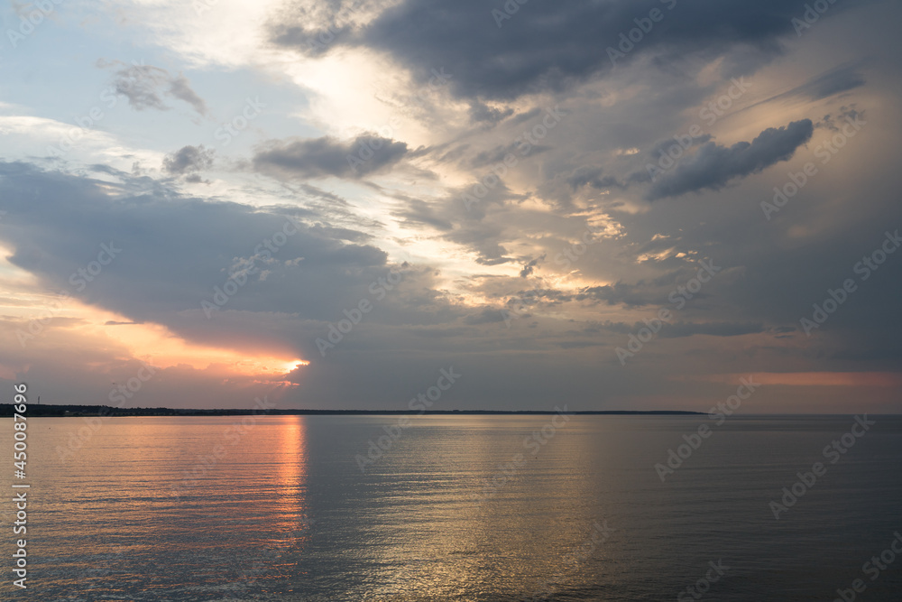 Kuivastu Estonia - June 22 2021: Dramatic dawn. Nordic white nights. Sunset on the Baltic Sea, Western coast of Estonia. Reflections of the colors on the water. Midsummer in the North.