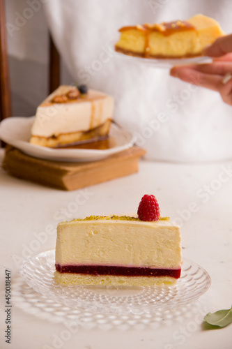 Sweet cakes concept. Cheesecake with raspberry jam on a light background