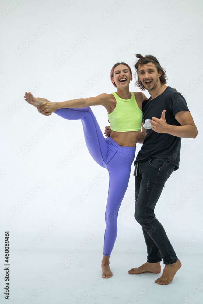Cheerful young couple fooling around, smiling and laughing. Isolated on white background. Man holding girlfriend on his arms. Studio photo. Cheerful young couple fooling around, smiling and laughing. Isolated on white background. Man holding girlfriend on his arms. Studio photo.