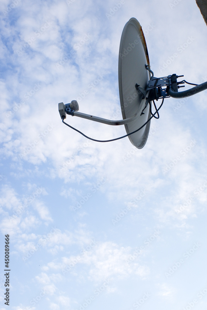 Satellite dish for television on a background of blue sky.