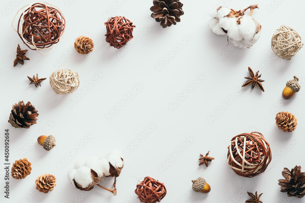 Autumn composition. Frame made of cotton, pine cones, anise, ball decorations on white background. Flat lay, top view, copy space. Autumn composition. Frame made of cotton, pine cones, anise, ball decorations on white background. Flat lay, top view, copy space.