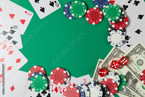 Classic playing cards, chips, red dice and dollars on green background. Gambling and casino concept.