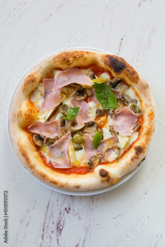 Round neapolitan pizza with ham and mushrooms