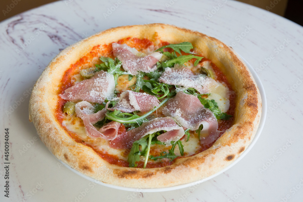 Neapolitan prosciutto pizza with arugula and cheese