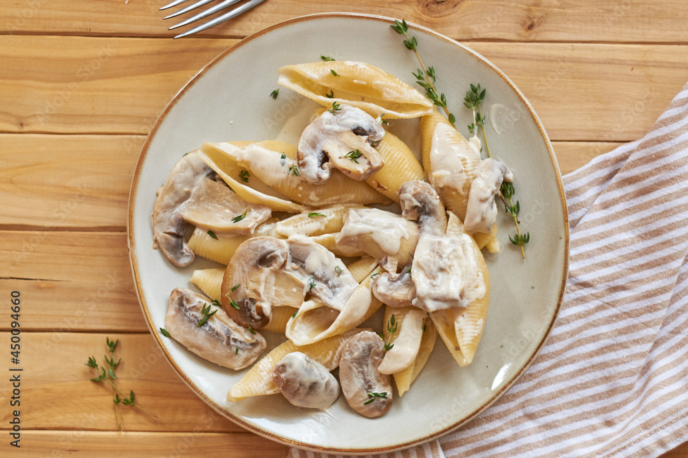 Creamy pasta with mushrooms and thyme. Top view, wooden background. Creamy pasta with mushrooms and thyme. Top view, wooden background.