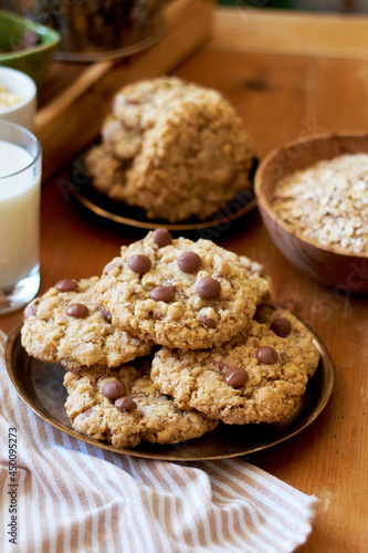 Oatmeal Chocolate Chip Cookies. Wooden table, side view, milk, chocolate, oatmeal.