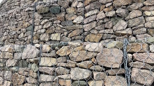 Gabion wall constructed using steel wire mesh basket. Stone walls, protection from backshore erosion. Gabion and rock armour-coastal and waterways protection photo