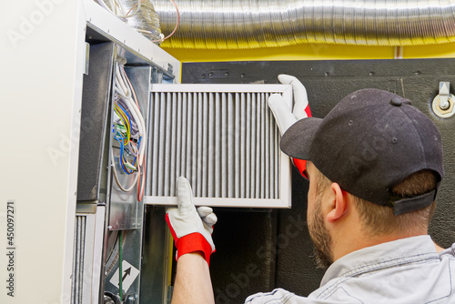 Fényképezés HVAC service technician changing dirty air filter in the central ventilation system