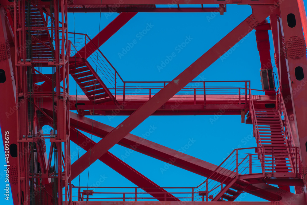 Red metal structures with stairs on a blue sky background, pattern or texture Red metal structures with stairs on a blue sky background, pattern or texture