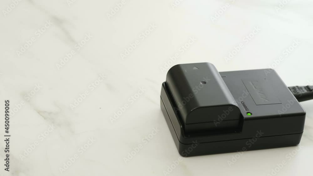 Charging the black battery for photo camera Charging the black battery for photo camera