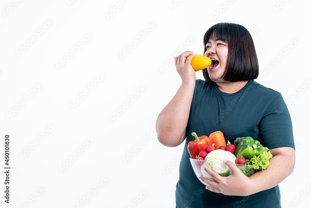Asian attractive fat woman eating and holding glass bowl  contains fruit and fresh vegetables On white background, to woman with health food and weight loss concept.