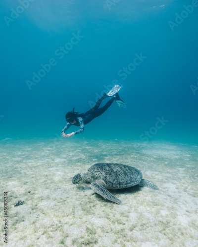 Freediver diving down to meet turtle