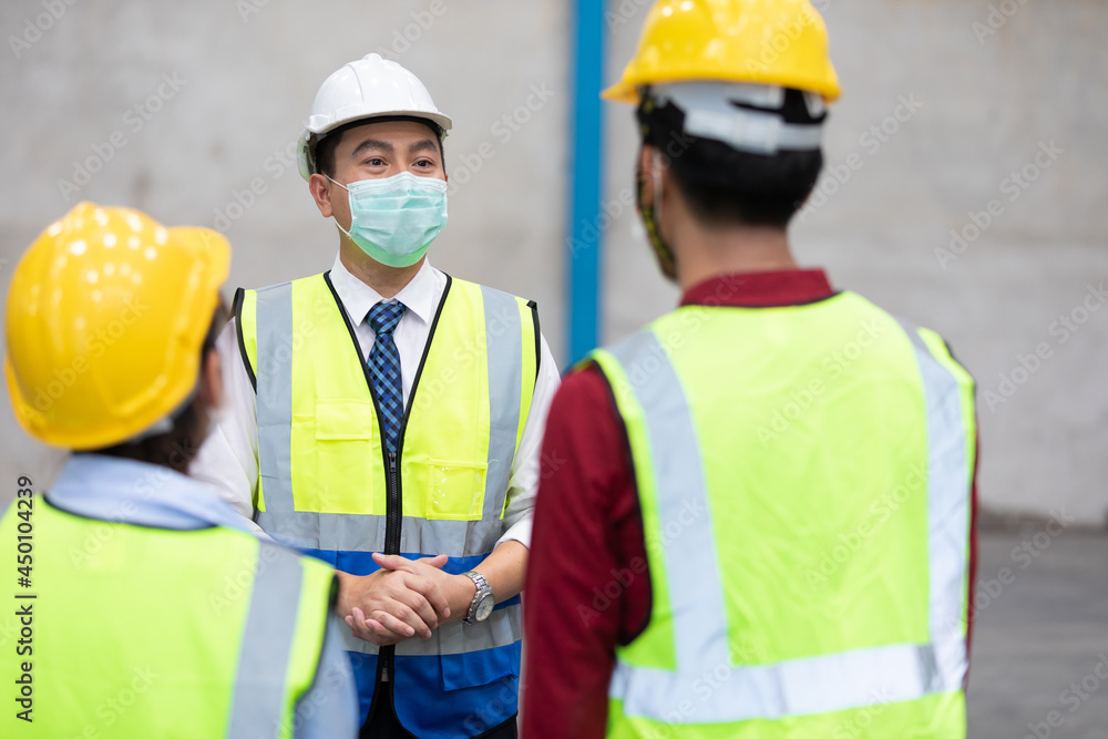 factory worker wearing medical face mask and talking about work with colleague factory worker wearing medical face mask and talking about work with colleague