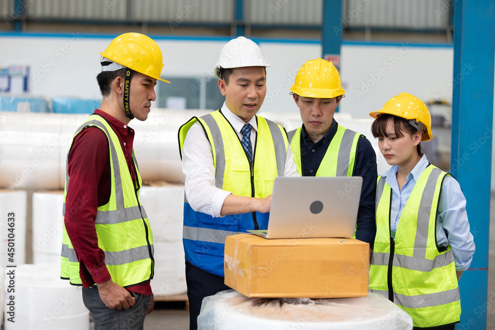 factory workers meeting and using laptop computer for work in warehouse storage factory workers meeting and using laptop computer for work in warehouse storage