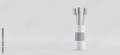 Toothbrushes in glass for oral cavity care. Grey plastic set tooth brushes for mouth cleaning in ceramic cup isolated on white background  dental hygiene  mockup banner. Realistic 3d illustration