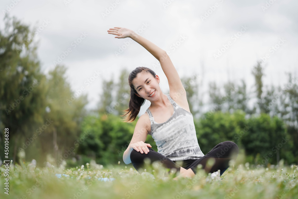 Asia woman practices yoga and meditates at park. Healthy lifestyle and Yoga concept.