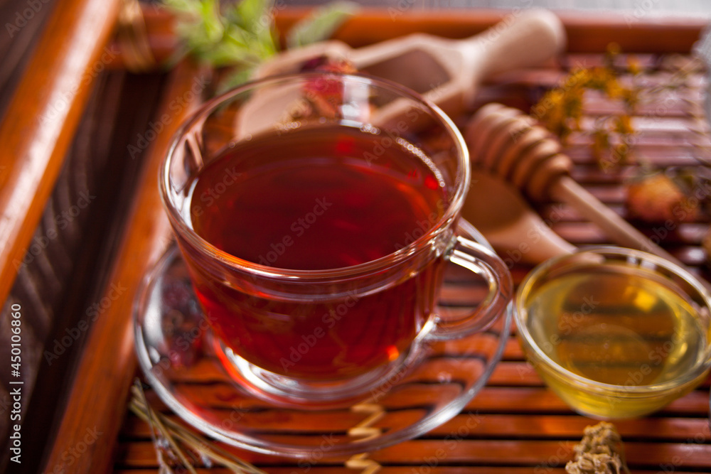 Cup of herbal tea with small bowl with honey on the tray. Cup of herbal tea with small bowl with honey on the tray.