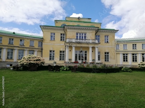 Andrianovo,Leningrad region,Russia-August,8,2021.Manor Marino.Stroganov-Golitsyn's palace and park.huge bushes of hydrangea with outdoor wicker furniture near yellow manor house with white columns