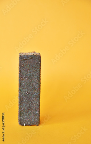 Fototapeta Naklejka Na Ścianę i Meble -  Chalk Eraser in used condition isolated on yellow background 