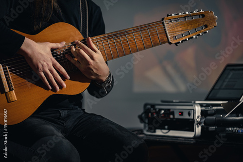 Konstfotografi Closeup of guitarist playing an electric acoustic ten-string midi guitar during