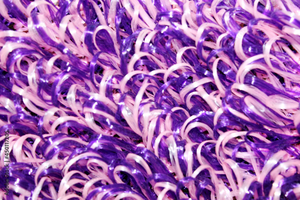 purple and white washcloth close-up. The view from the top. Texture. Background. Abstraction. Knitted washcloth. Self-care. The washcloth is made of propylene thread