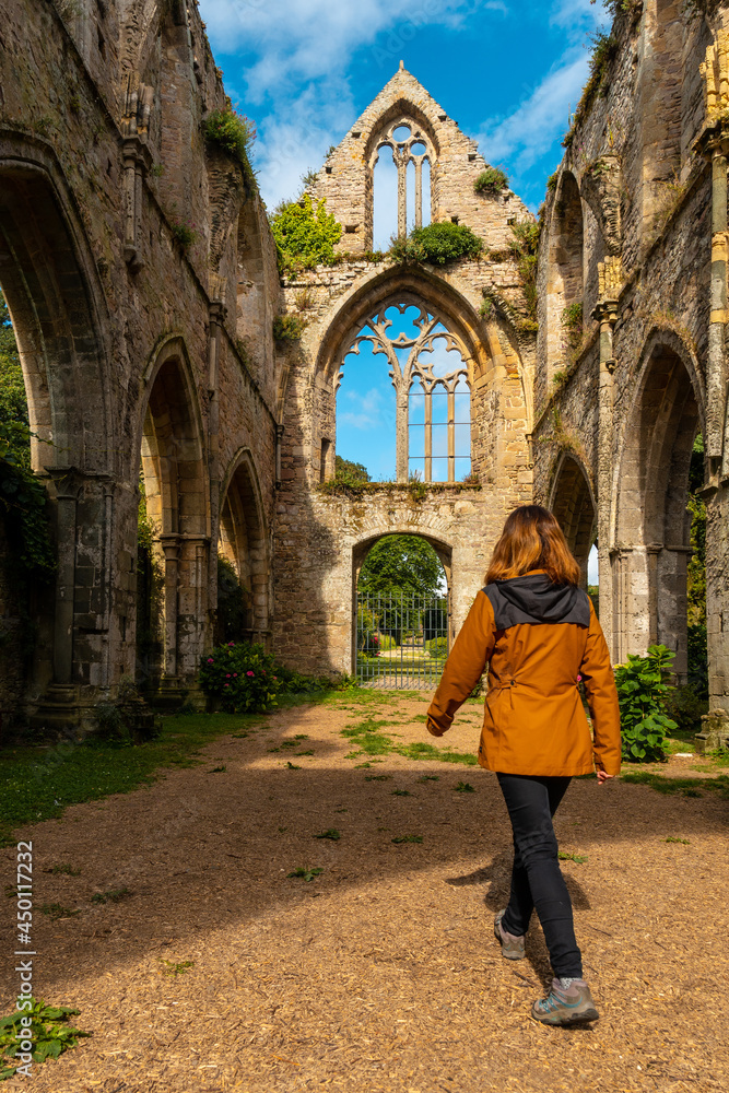 A young woman visiting the ruins of the Abbaye de Beauport church in the village of Paimpol, Côtes-d'Armor department, French Brittany. France