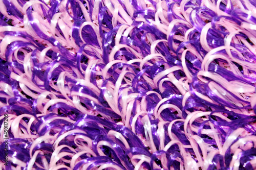 purple and white washcloth close-up. The view from the top. Texture. Background. Abstraction. Knitted washcloth. Self-care. The washcloth is made of propylene thread
