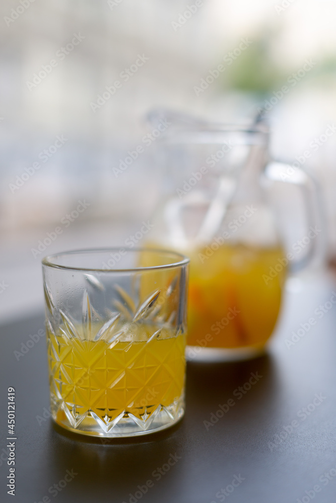 A pitcher of lemonade and a glass of lemonade in a summer cafe on the table A pitcher of lemonade and a glass of lemonade in a summer cafe on the table