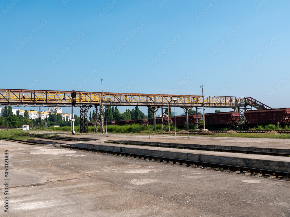 Railroad station. Long iron footbridge across the railroad tracks.