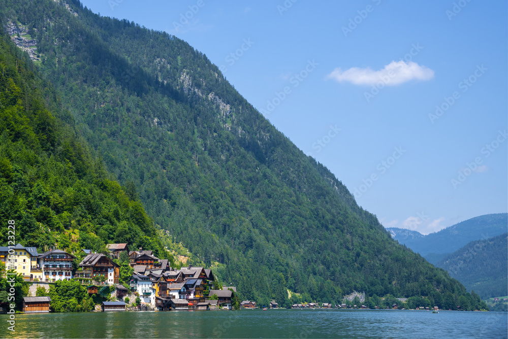 Hallstatt, Austria ; August 6, 2021 - A scenic picture postcard view of the famous village of Hallstatt reflecting in Hallstattersee lake in the Austrian Alps.
