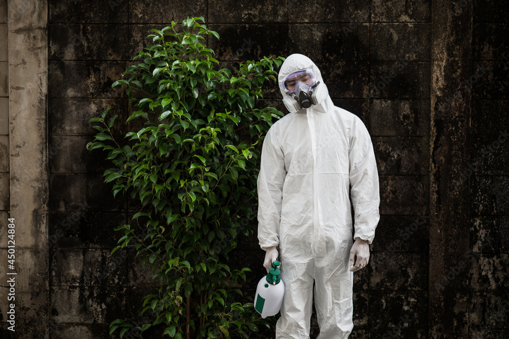 Disinfection specialist man in PPE suit performing public decontamination