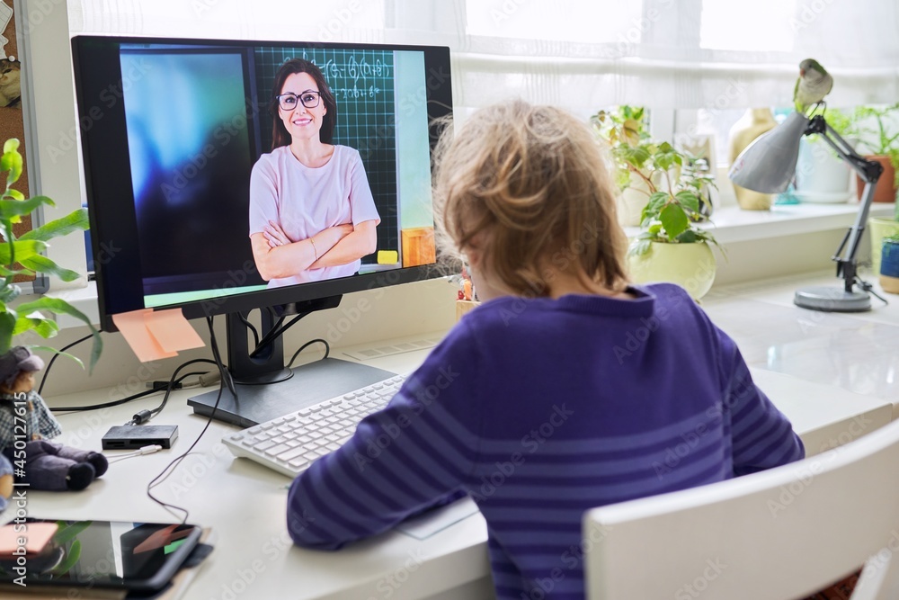 Preteen girl learning math online using home computer stock photo