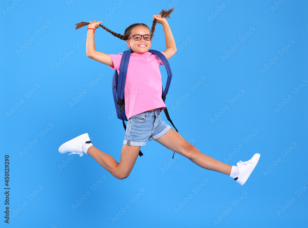 Energetic happy schoolgirl in eyewear with funny surprised facial expression jumping up in air Energetic happy schoolgirl in eyewear with funny surprised facial expression jumping up in air