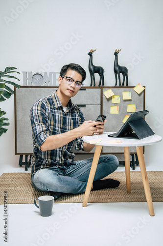 Young man working from home with digital tablet and smartphone