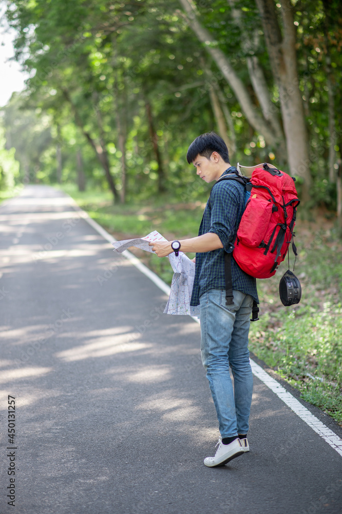 Young backpacker man looking map while working in trip