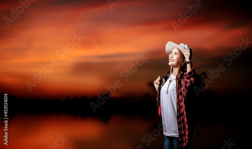 Young packpacker female standing with beautiful nature sunset photo