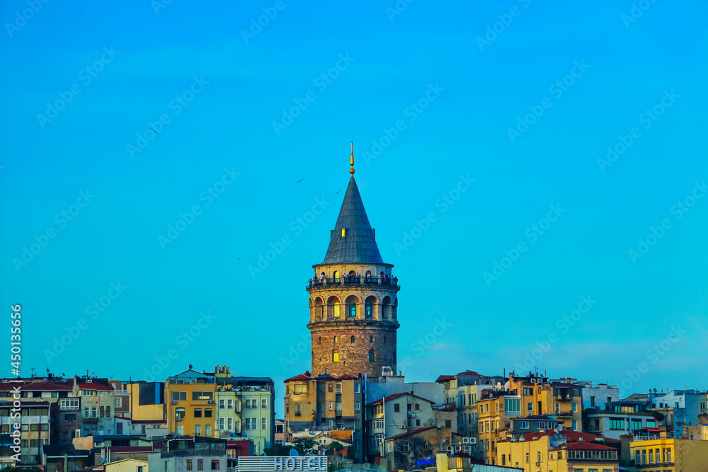 selective focus, magnificent galata tower joins the unique color gamut of the sunset. orange galata tower under the blue sky
