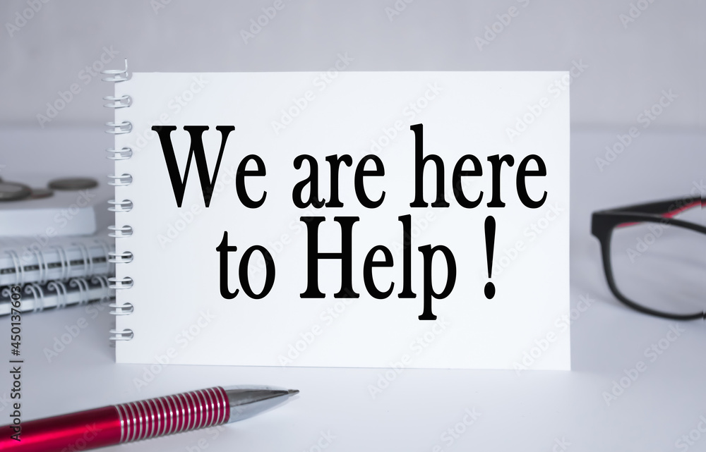 text WE ARE HERE TO HELP . Notepad with eyeglasses and text documents. Business concept text WE ARE HERE TO HELP . Notepad with eyeglasses and text documents. Business concept