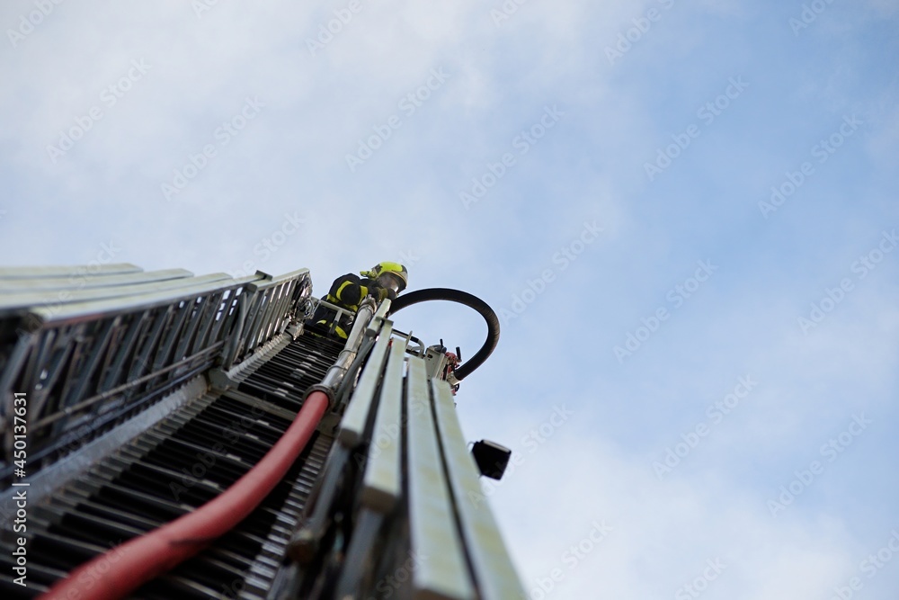 Fototapeta premium Firefighter in a basket of fire truck ladder
