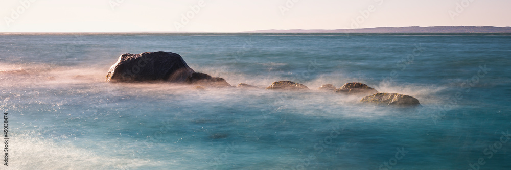 Fototapeta premium Seascape with ancient glacial rocks and steaming seawater on the Cape For the beach. Zen-like ocean view over the Martha's Vineyard in Massachusetts.