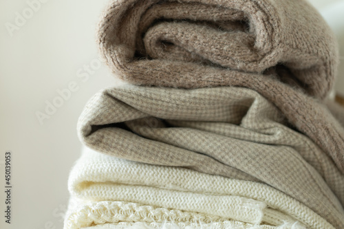 Pile of knitted sweaters. Warm background, knitwear, space for text. Autumn winter concept. Background with sweaters
