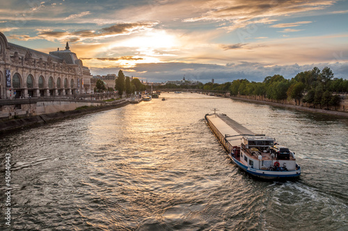 Transport fluvial sur la Seine vue du Pont Royal au crépuscule à Paris