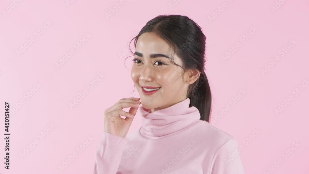 Beauty concept of 4k Resolution. Asian girl is touching her face on a pink background. Beauty concept of 4k Resolution. Asian girl is touching her face on a pink background.