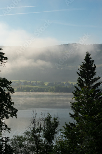 Early morning view over Lac de Joux, Switzerland, towards the misty Jura mountains during sunrise