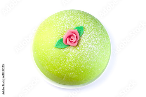 Traditional Swedish dessert Princess cake with green marzipan cover and pink rose decoration, isolated on white, top view