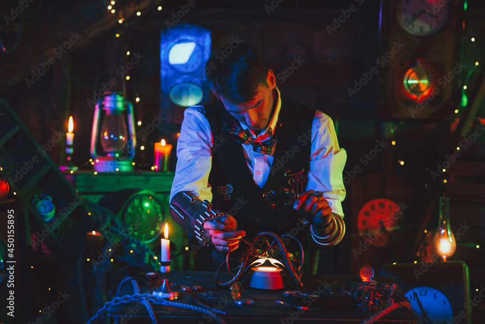 male inventor in a steampunk suit repairs the mechanism. A watchmaker with tools and a magnifying glass works male inventor in a steampunk suit repairs the mechanism. A watchmaker with tools and a magnifying glass works