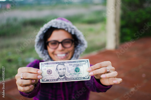woman showing dollar bill, close up of a woman showing a five dollar bill photo