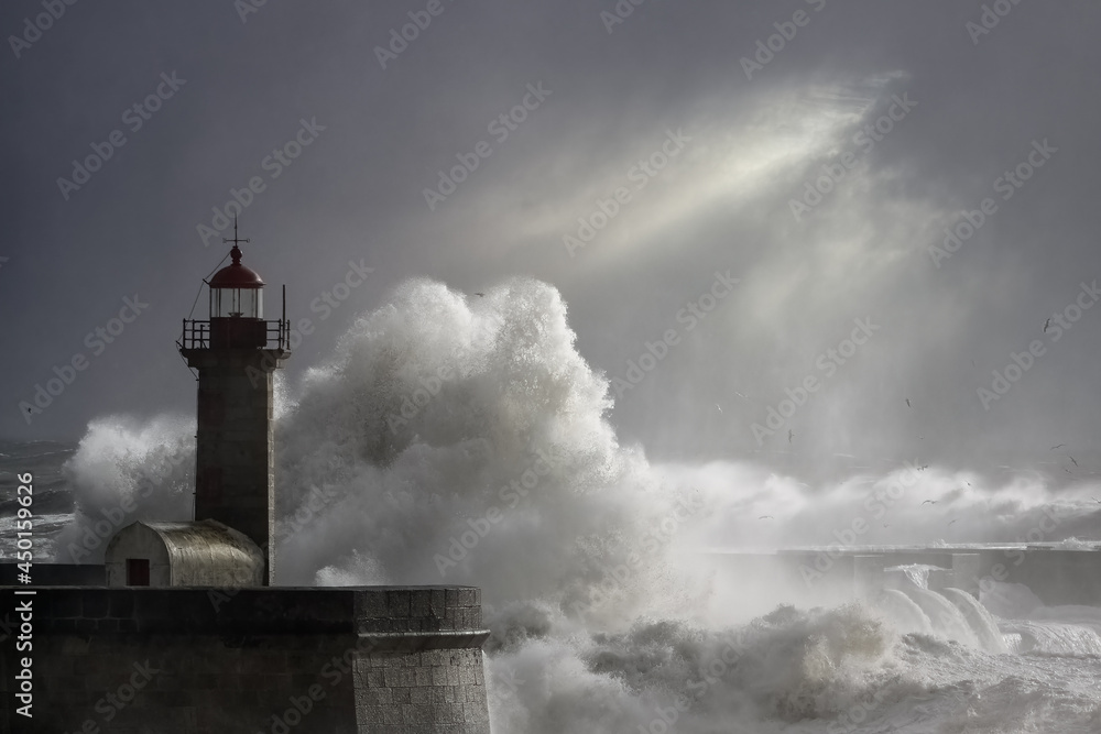 Dramatic seascape with stormy waves over lighthouse