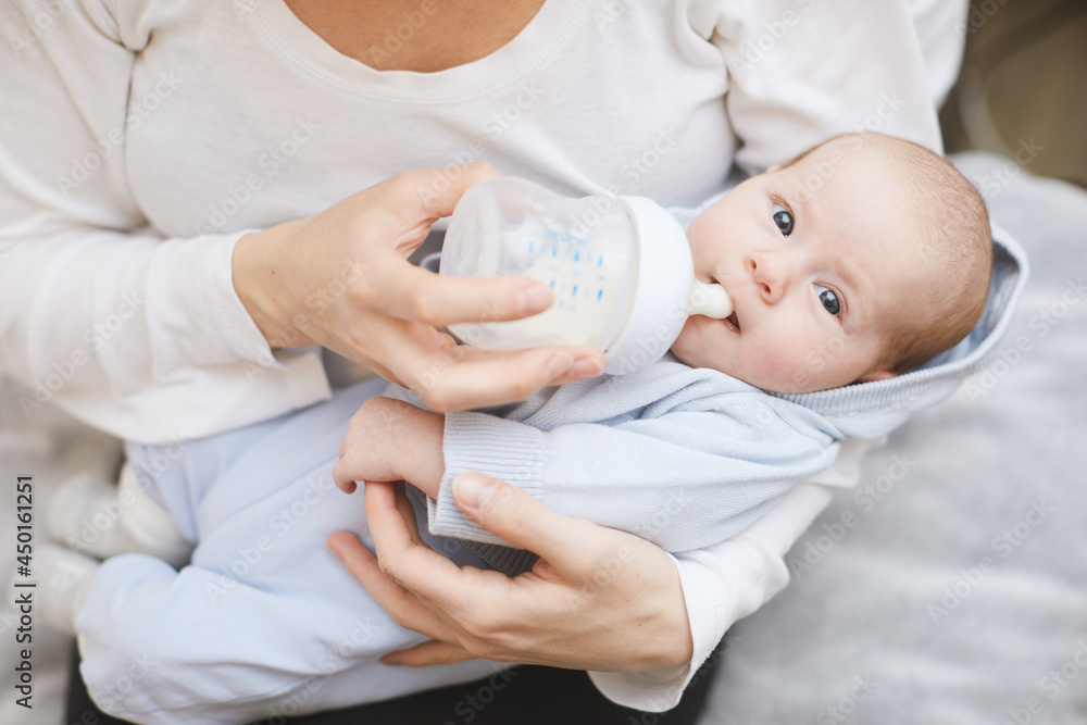 Baby eats milk from a bottle in leaving room. Baby eats milk from a bottle in leaving room.